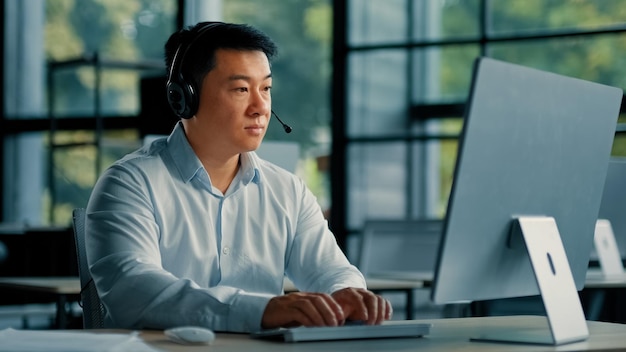 Asian businessman consultant adviser teacher in headphones work at helpline company support client