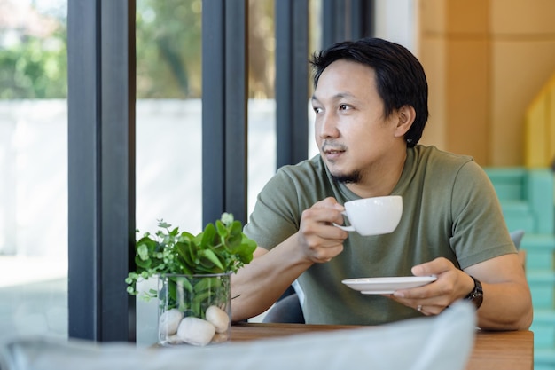 사진 행복감을 느끼며 집에서 술을 마시고 일하는 아시아 사업가