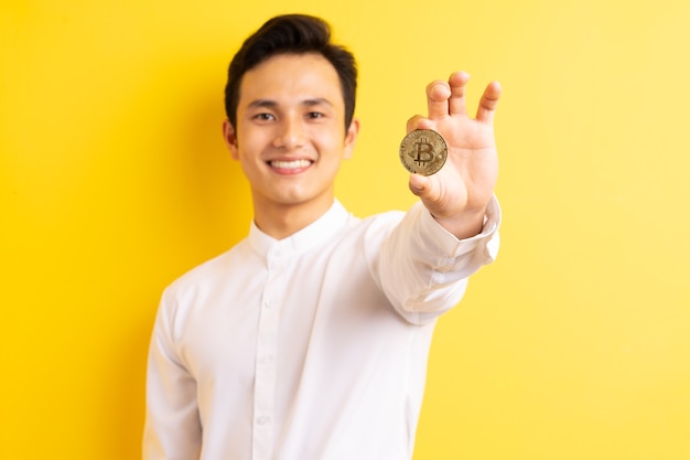 Asian businessman holding bitcoin in his hand wite happy face
