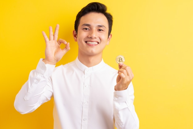 Asian businessman holding bitcoin in his hand wite happy face