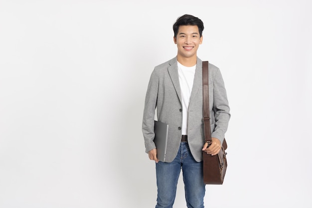 Asian businessman holding laptop and brown leather bag isolated on white background