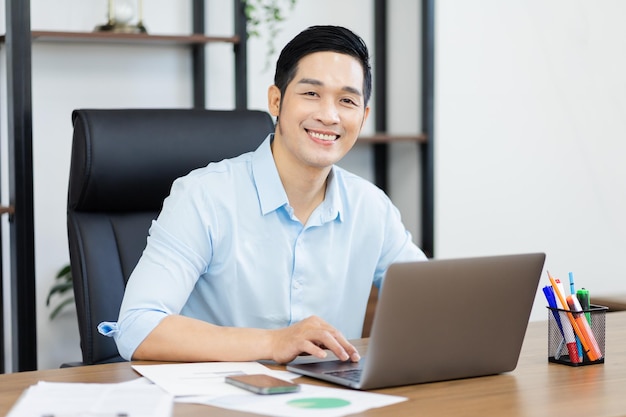 Asian businessman male portrait sitting at his desk