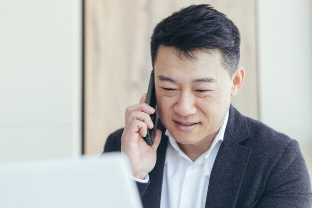 아시아 사업가 초상화 성공적이고 행복한 미소로 비즈니스 정장을 입고 전화 통화