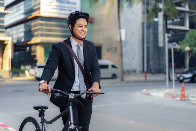 Asian businessman pushing his bicycle from home