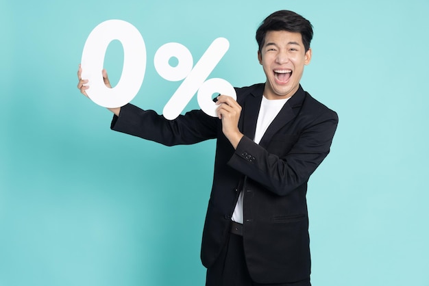 Азиатский бизнесмен показывает и держит ноль процентов на светло-зеленом фоне