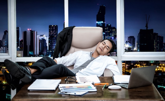 Asian businessman sleeping while working with computer at his working place