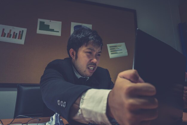 Asian businessman under stress due to excessive workFeeling exhaustedYoung clerk has a problem in a officesad man from workAngry messy man concept