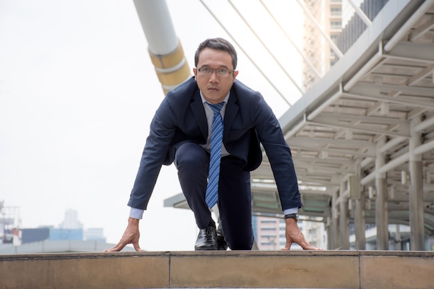 asian businessman in suit preparing to run,getting ready to run the race