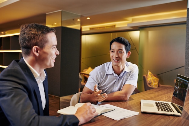 Asian businessman talking to colleague