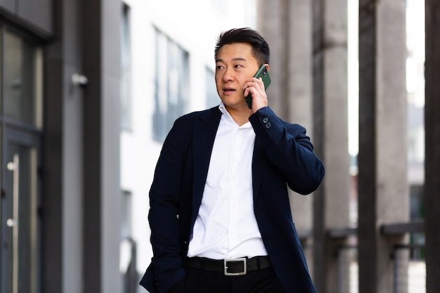 Asian businessman talking on the phone serious has an angry conversation