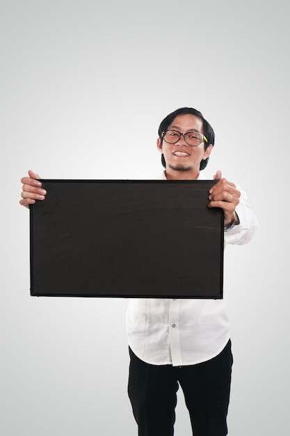 Asian businessman or teacher or student showing empty blackboard with smiling face