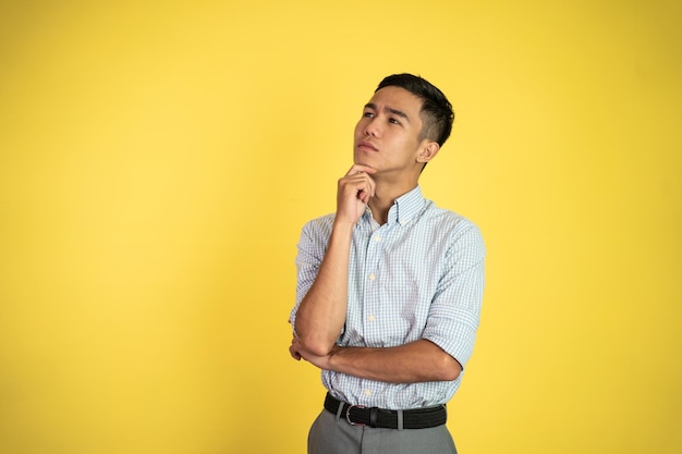 Asian businessman thinking something and looking up