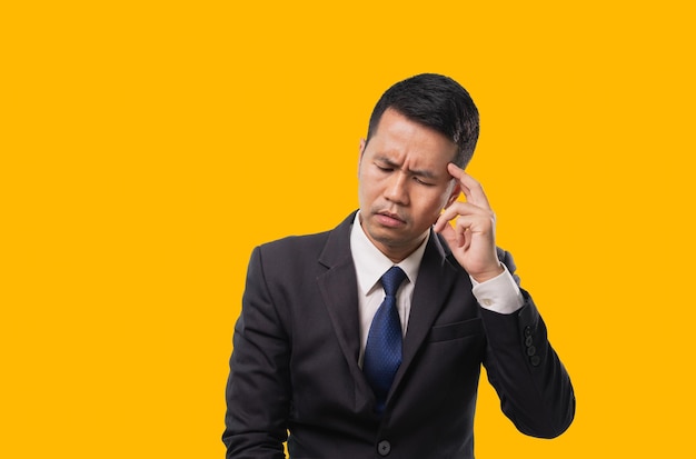 Asian businessman touching his head with his hand Expressing stressful gestures depression unhappy and headaches Business concept