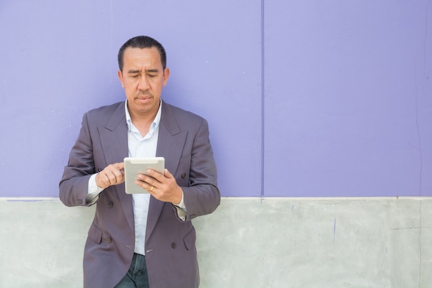 Азиатский бизнесмен использует цифровой беспроводной планшетный компьютер