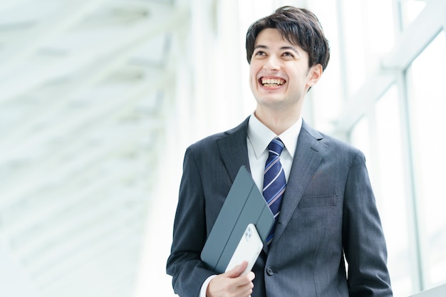 Asian businessman walking down the aisle with a smile