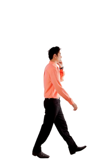Фото Азиатский бизнесмен ходит, разговаривая по телефону, изолированный над белым.