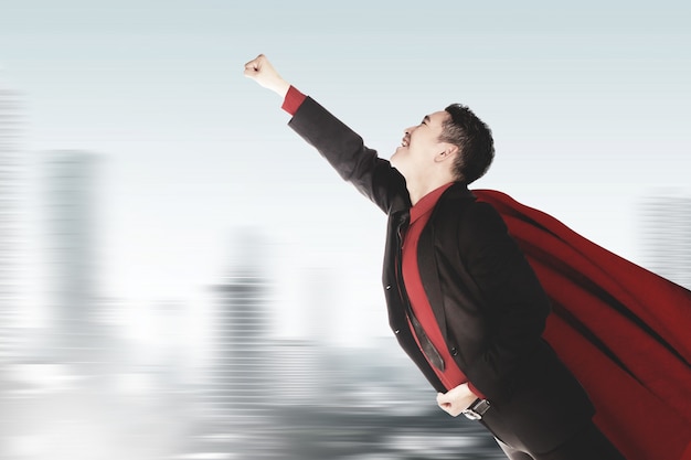Фото Азиатский бизнесмен с плащом, летящим как супергерой