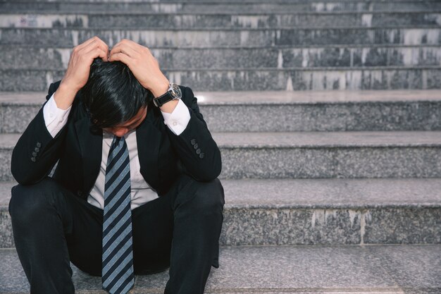 Asian businessmen with headaches or migraines at the city hall after work 