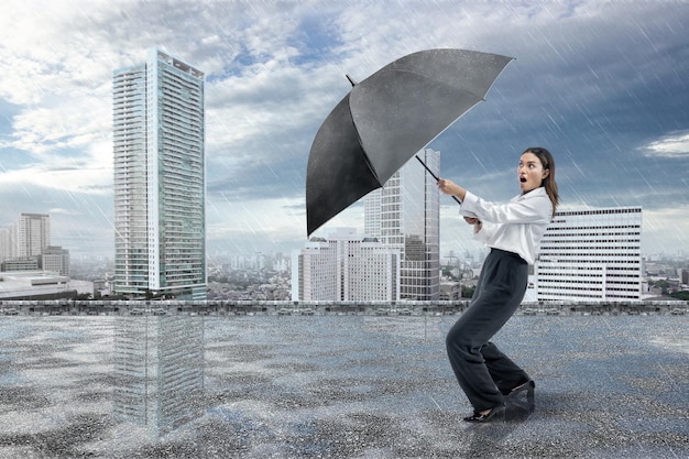 Asian businesswoman holding a black umbrella