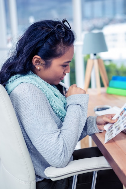 Asian businesswoman holding paper sheet in office