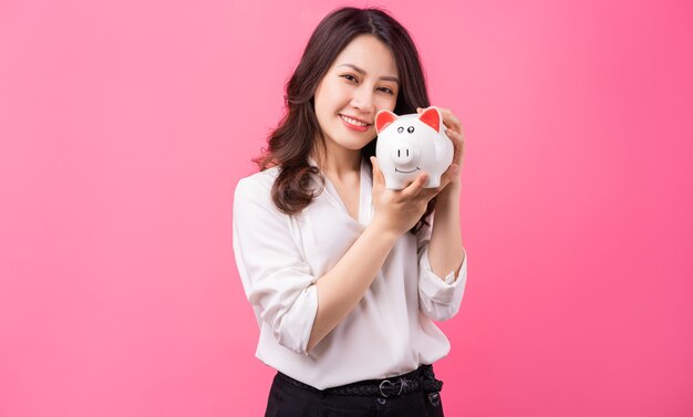 Asian businesswoman holding piggy in her hand, saving money concept