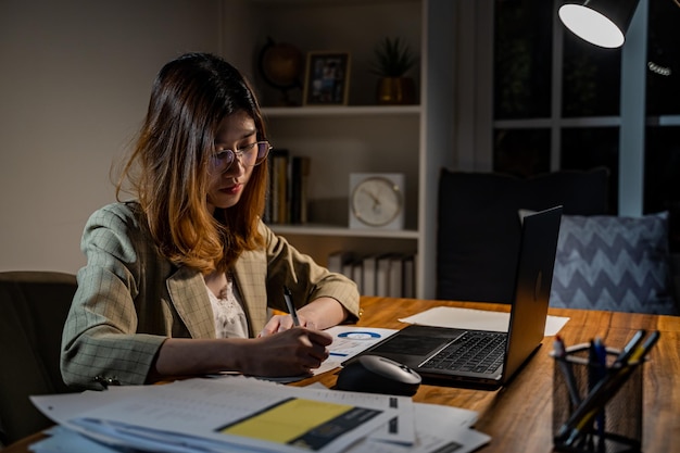 Азиатская деловая женщина онлайн работает по ночам. Занят и измучен сверхурочной работой дома