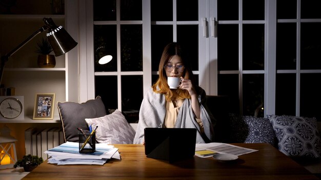 Asian businesswoman online working at the night. Busy and exhausted of work overtime at home