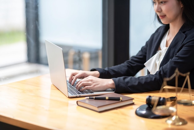 사진 사무실에서 법률 업무 상담을 위해 노트북 키보드를 사용하여 직장에 앉아 있는 아시아 여성 사업가 또는 변호사