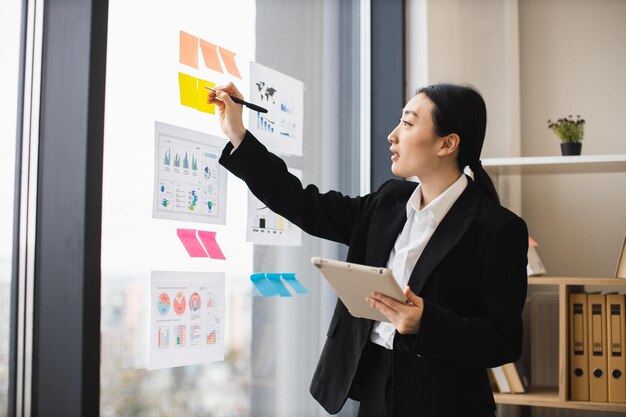Photo asian businesswoman presenting analysis with graphics and tablet