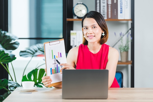 집에서 노트북으로 화상 통화를 통해 비즈니스 보고서를 발표하는 아시아 여성 사업가입니다. 기업인 또는 기업가 작업, 온라인 쇼핑, 전자 상거래, 인터넷 뱅킹, 가정 개념에서 작업