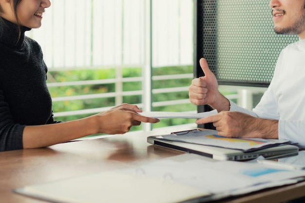 Asian businesswoman sent her work to manager and her manager thumb up.