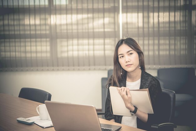 Стресс азиатской деловой женщины от тяжелой работыТайская работница, работающая в офисе