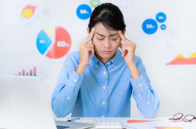 Situazione stressante della donna di affari asiatica mentre lavorando - concetti di finanza e di affari.