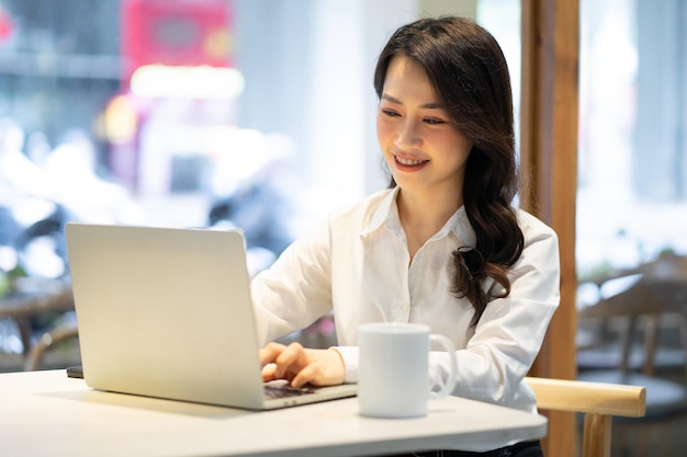 Donna di affari asiatica che lavora ad un caffè