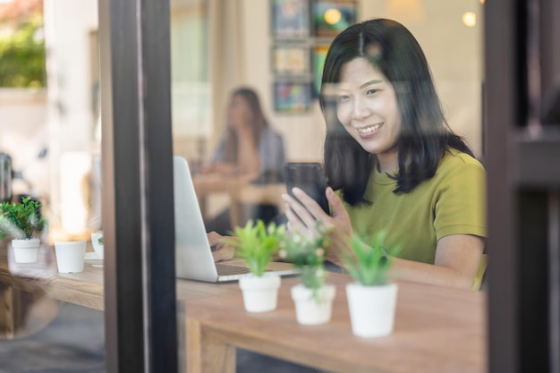 Photo asian businesswoman working from home with mobile phone and technology laptop