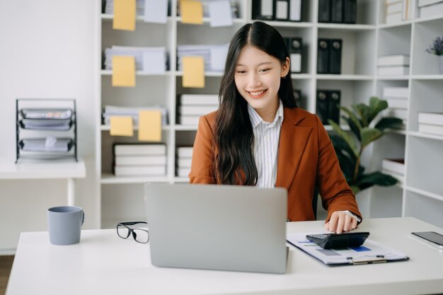 Photo asian businesswoman working in the office with working notepad tablet and laptop documents in office