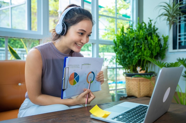 Asian businesswomen is using notebook computers and wear headphones for online meetings and working from home.