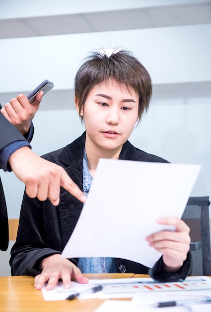 아시아 경제인들이 사무실에서 동료와 함께 일하고 있다