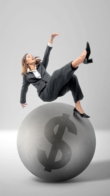 Asian businesswomen slipped while on a ball with a dollar sign