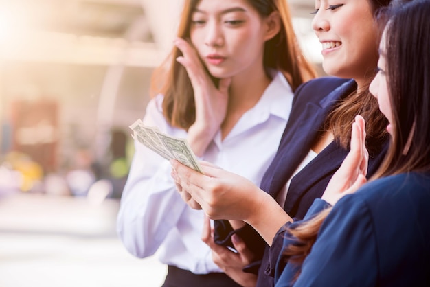 Asian businesswomen with colleague hold money for success