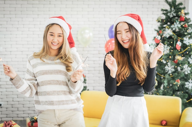 Asian cheerful attractive young woman in Santa Claus hat standing and dancing 