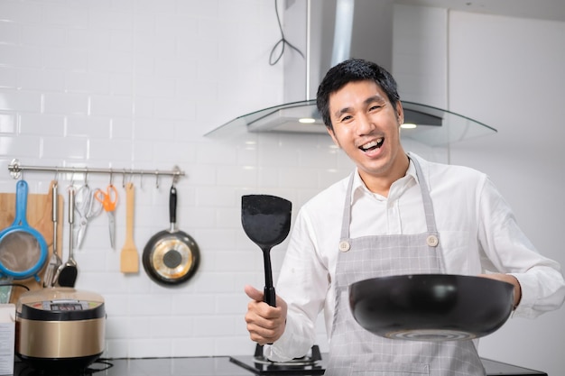 Asian chef fried eggs on pan to thai food in kitchen