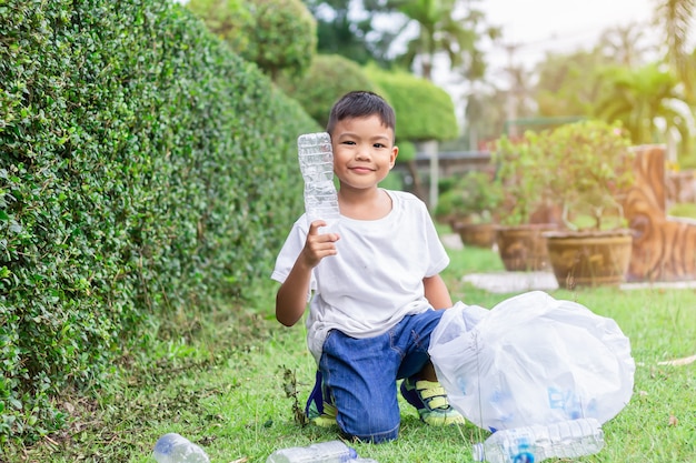 Asian child boy is a volunteer for clean up the field floor.