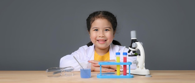 Ragazza asiatica del bambino che impara la chimica della scienza con la provetta che fa l'esperimento al laboratorio della scuola. concetto di educazione, scienza, chimica e bambini. sviluppo precoce dei bambini.