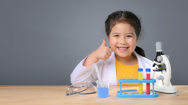 Ragazza asiatica del bambino che impara la chimica della scienza con la provetta che fa l'esperimento al laboratorio della scuola. concetto di educazione, scienza, chimica e bambini. sviluppo precoce dei bambini.