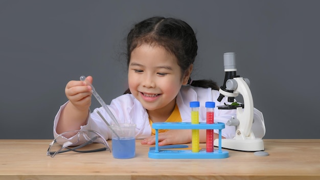 Ragazza asiatica del bambino che impara la chimica della scienza con la provetta che fa l'esperimento al laboratorio della scuola. concetto di educazione, scienza, chimica e bambini. sviluppo precoce dei bambini.