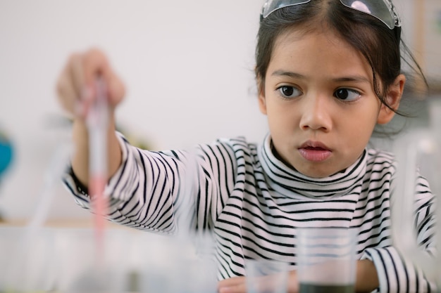 Asian child girl learning science chemistry with test tube making experiment at school laboratory education science chemistry and childrens concepts Early development of children