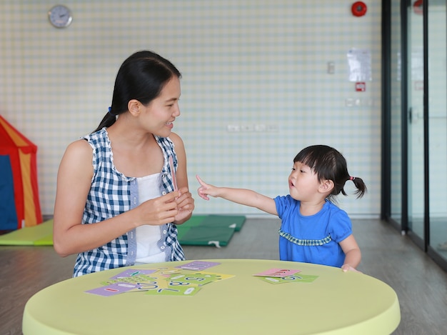 遊び場での右脳発達のためのアジアの子供の女の子と母親のフラッシュカード