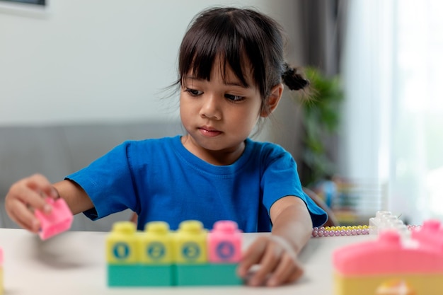 ホームスクーリングのための創造的なおもちゃのブロックを再生するアジアの子供の女の子