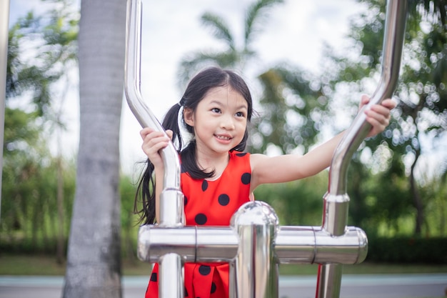 Asian child girl playing on playground in summer time